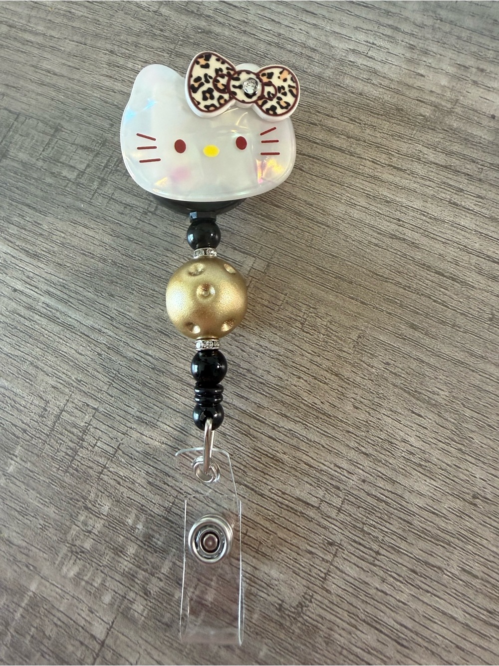 Iridescent White Kitty Badge Reel with Gold and Black Bead Accent